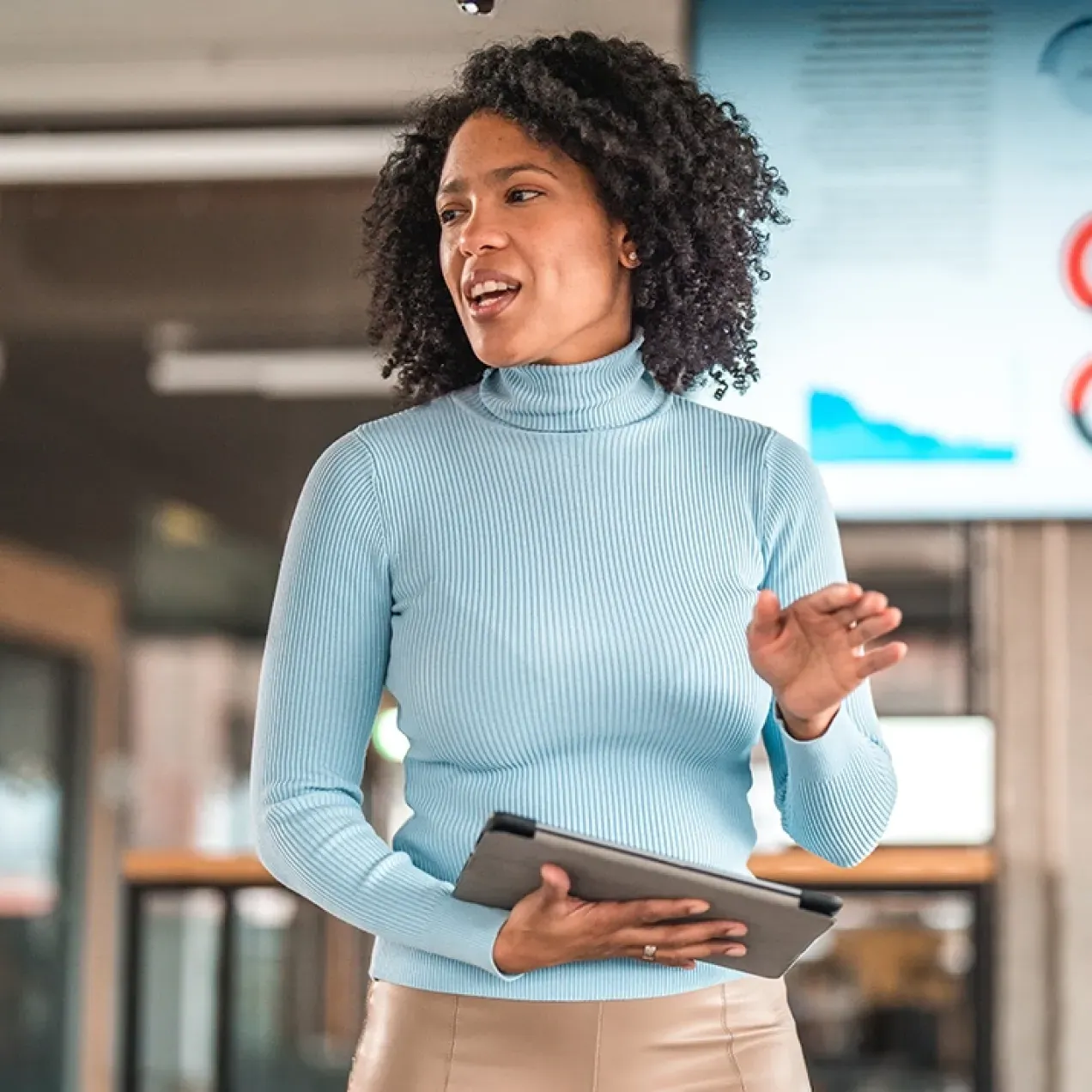 A confident business professional presents data during a meeting, demonstrating leadership and analytical skills gained through an MBA.